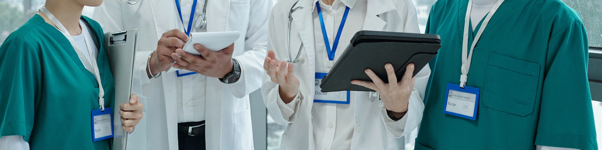 Medici e infermieri consultano cartelle e tablet in una struttura sanitaria